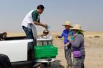 Eddie Melendrez, community organizer for Oregon Food Bank, hands farmworkers resources on July 24, 2026, in Ontario, Ore., as smoky conditions and soaring temperatures continue.