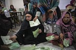 Pakistani election workers sort ballot papers at the start of the vote count in Thursday's general elections, at a polling station in Lahore, Feb. 8.