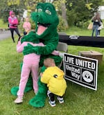 Kids hug the Awesome 3000 mascot, Geo the Alligator, at the annual fun run on April 27, 2024, in Salem, Ore.