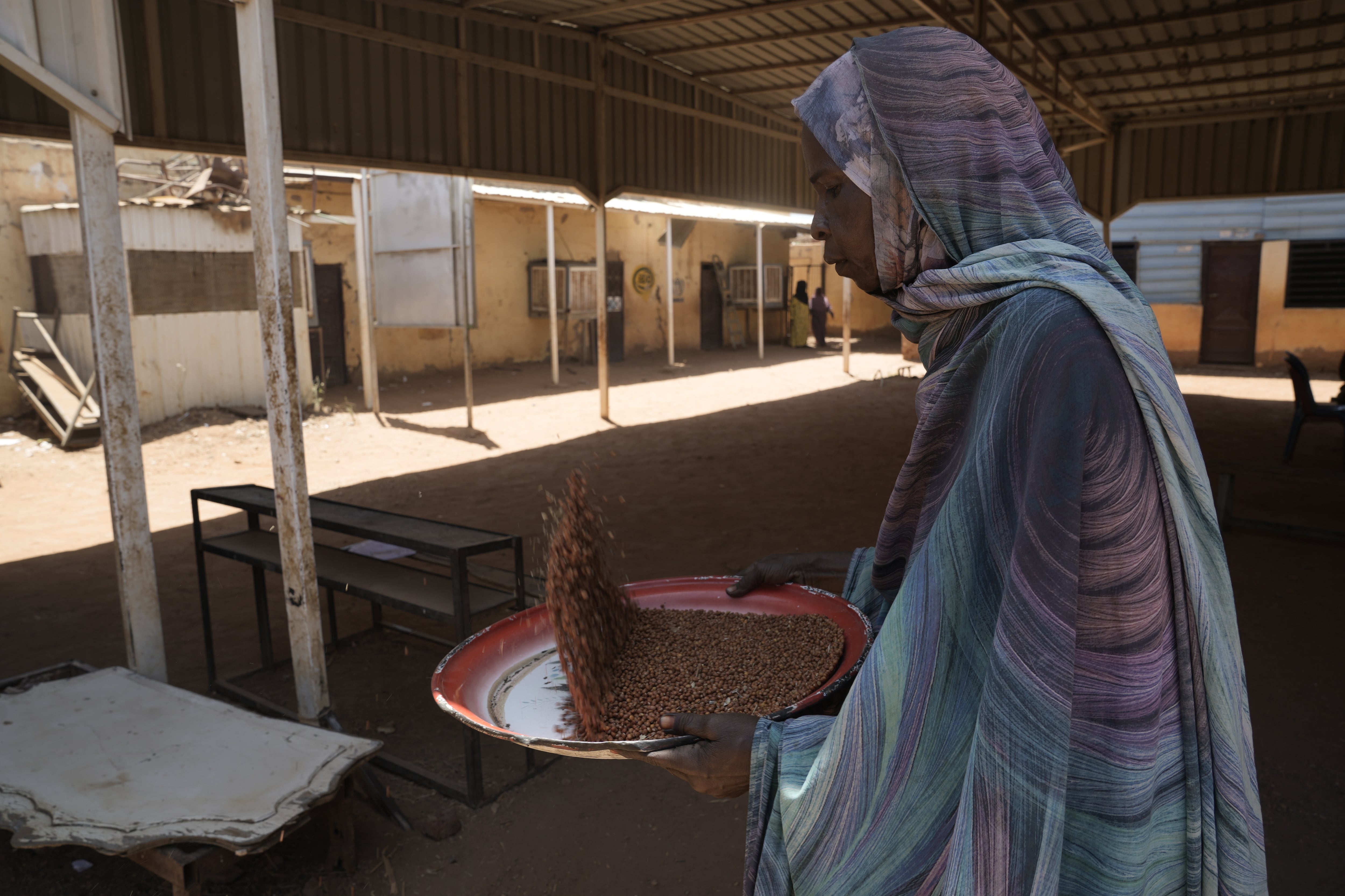 A volunteer at a community kitchen in Khartoum prepares food to be distributed to those in need.