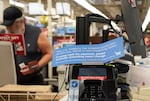 A sign asking customers to use exact change is posted at the register at Fred Meyer on Hawthorne Boulevard in Portland, Ore., on Tuesday, Dec. 16, 2025.