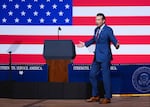 Defense Secretary Pete Hegseth speaks to senior military leaders at Marine Corps Base Quantico in front of a large U.S. flag