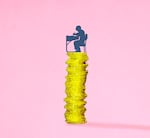 Illustration of a boy sitting at a school desk atop a stack of gold coins.