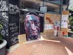 George Floyd's face is painted on plywood covering the walls of downtown Portland's Eddie Bauer store.