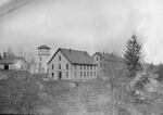 Laundry hangs on a line to dry outside one of Multnomah County's Hillside Poor Farm buildings, circa 1898.