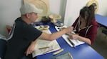 Greg works with artist Ceara Lewis guiding her on the art of carving at the Lifeways Program