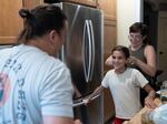 Andrew DiDonato looks on as his wife Ashley pulls their daughter Rosalie's hair back to match her dad's in their home in Philadelphia on July 22, 2024.
