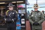 Officers guard a sidewalk memorial for slain Seaside Police Sgt. Jason Goodding.