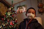 Angel, 6, poses in front of a Christmas tree at his home on Wednesday, Dec. 23, 2020, in Santa Fe, N.M. Angel's parents, both cooks, struggled to pay rent this year as their hours were cut in half. As immigrants in the country without work permission, they're ineligible for state unemployment or federal stimulus money.