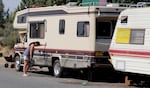 Sydney Moe, exhausted from the heat, leans on her son's RV on Clausen Road in Bend. The city of Bend completed its removal of RVs and tents in the area this week.