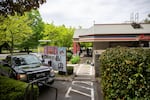 Graffiti covers the drive-thru menu at Burgerville in Portland, Ore., Friday, May 1, 2020. May Day demonstrators demanded personal protective equipment and hazard pay for frontline workers during the COVID-19 pandemic.