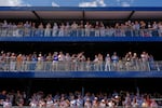 Spectators watch as President Trump, in the presidential limousine known as "The Beast," does a lap around the track before the IndyCar Freedom 250 Grand Prix auto race.