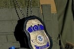 File image from May 7, 2025 in Newark, N.J., shows a badge hanging over the uniform of an Immigration and Customs Enforcement (ICE) agent.