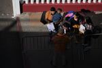 A migrant family shows their paperwork to Mexican immigration officials to proceed with their CBP One asylum appointments at the Chaparral pedestrian border in Tijuana, Mexico to cross to the U.S. on Thursday.