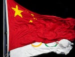 The Chinese and the Olympic flag wave during the opening ceremony of the 2022 Winter Olympics in Beijing. The World Anti-Doping Agency cleared 23 Chinese swimmers of doping allegations despite positive tests for banned substances, allowing them to compete in the 2021 Tokyo Games.