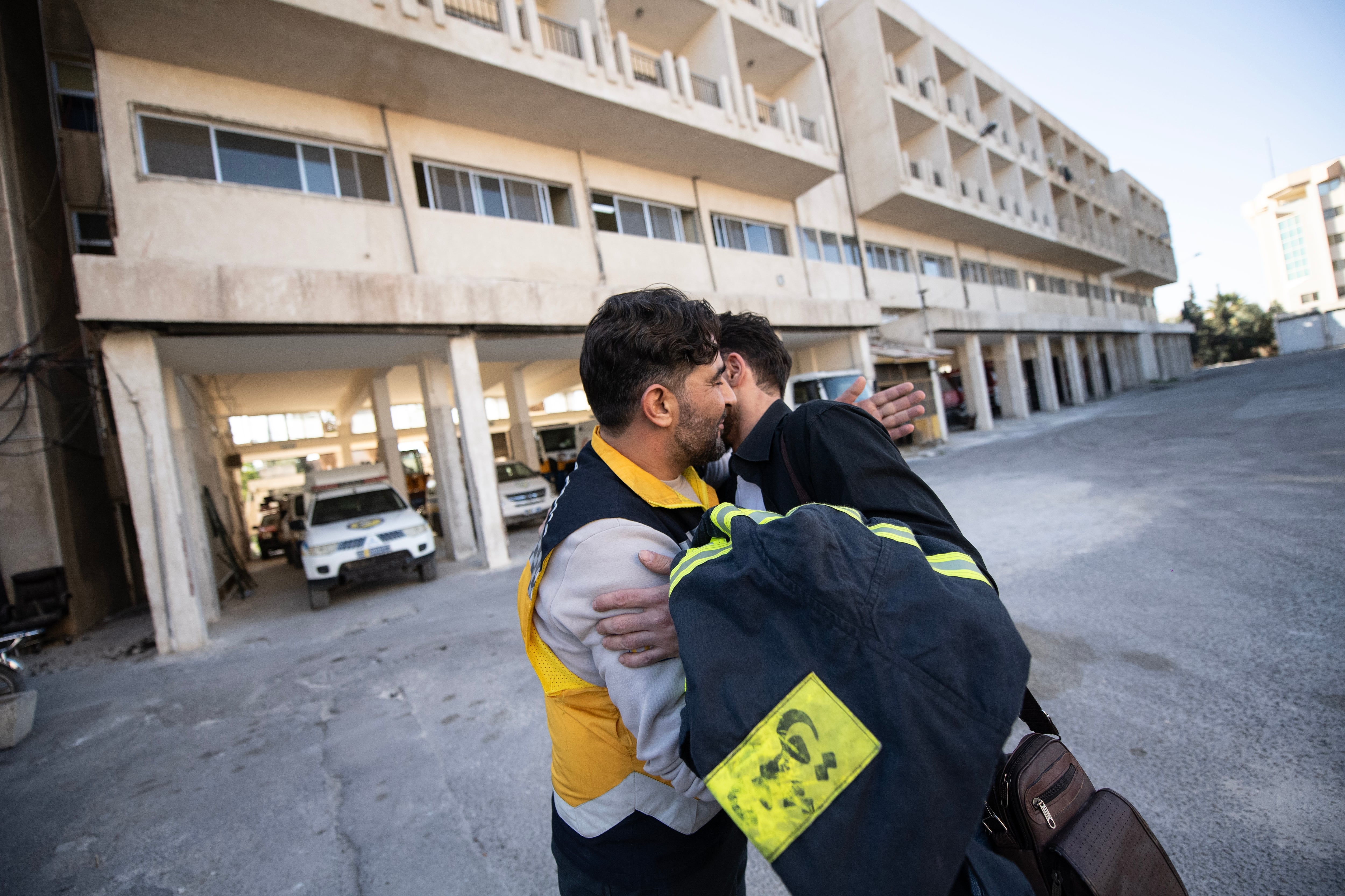 Mustafa Bakkar (left), operations chief for the White Helmets, hugs firefighter Mohammed Khdeir.