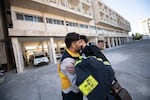 Mustafa Bakkar, left, operations chief for the White Helmets hugs another member of the white helmets.