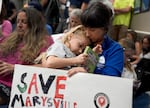 Martha Mosqueda cuddles with her daughter, June Jelsing, 6, during the meeting. June is a first grader at Marysville Elementary school, one of the 14 schools PPS is considering closing.