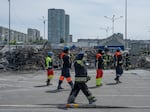 Emergency personnel clear debris at the site of a missile attack on a hardware superstore that killed 19 people in Kharkiv, Ukraine, on May 26.