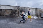 Children walk past the West Bank barrier, which separates Bethlehem from encroaching Israeli settlements.