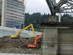 Workers add stone armor to the Willamette River bank on Zidell property as part of the company's environmental cleanup efforts along Portland's Waterfront.