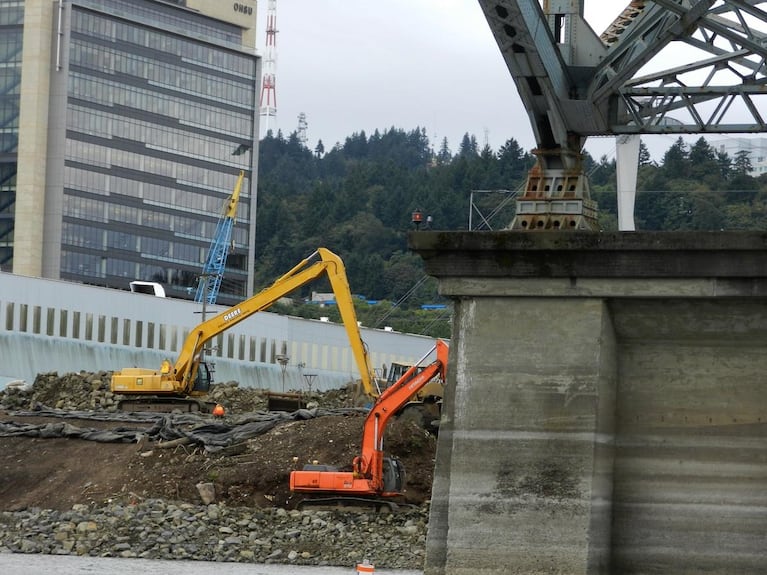 Workers add stone armor to the Willamette River bank on Zidell property as part of the company's environmental cleanup efforts along Portland's Waterfront.