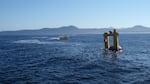 The OSU Ocean Sentinel test facility buoy (left) and the WET-NZ wave energy conversion device (right) during acoustic recording and monitoring sound levels at the site during device testing.