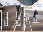 Workers attach siding to a house at a new home construction site in Trappe, Maryland, on October 28, 2022. Rising interest rates could mean slowing job growth in construction and manufacturing.