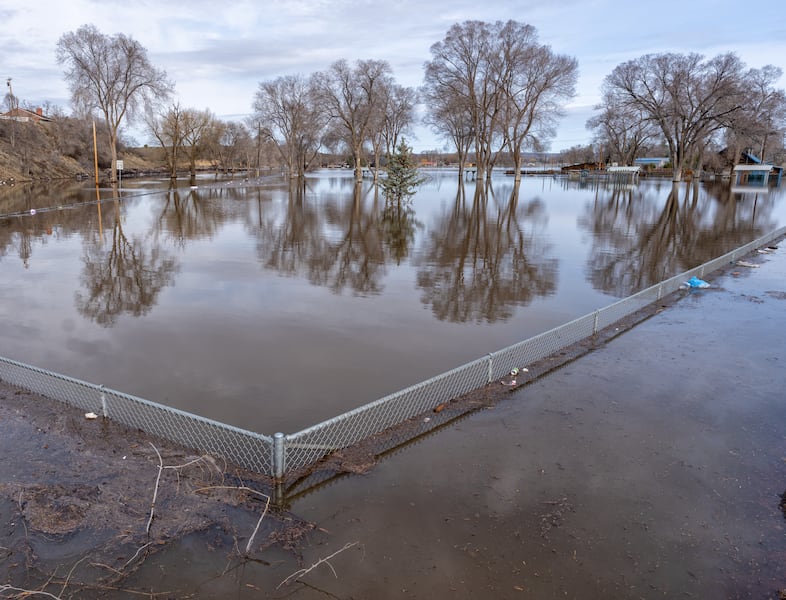 Floodwaters nearly cover the top of the fence line at  Triangle Park in Burns, Ore., March 30, 2025. 