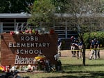 Investigators search for evidence outside Robb Elementary School in Uvalde, Texas, on Wednesday, the day after a mass shooting took place there.