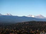 The Tumalo volcanic center as seen from Bend. The tallest point in front of the Sisters, between South and Middle, is Triangle Hill, at the middle of the volcanic center. Other nearby buttes and peaks are also a part of the complex.