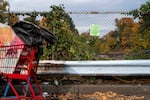 A notice of illegal camping is posted on the fence above the highway at an encampment of unhoused people in Portland, Ore., on Oct. 31, 2025.