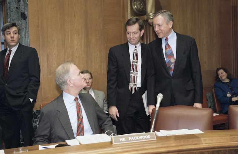 Sen. Orrin Hatch (R-Utah), right, and Utah Gov. Mike Leavitt, center, talk to Sen. Bob Packwood (R-Ore.), prior to a hearing of the Senate Finance Committee on Capitol Hill, Feb. 3, 1994 in Washington. The committee was to hold hearings on the states' perspective on health care reform.