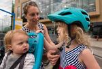 Annie Rudwick adjusts her daughter's helmet as they prepare for a bike ride.