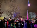 A crowd stands in downtown Milwaukie, Ore. as they wait for a giant Bing cherry light fixture to drop on Dec. 31, 2023.