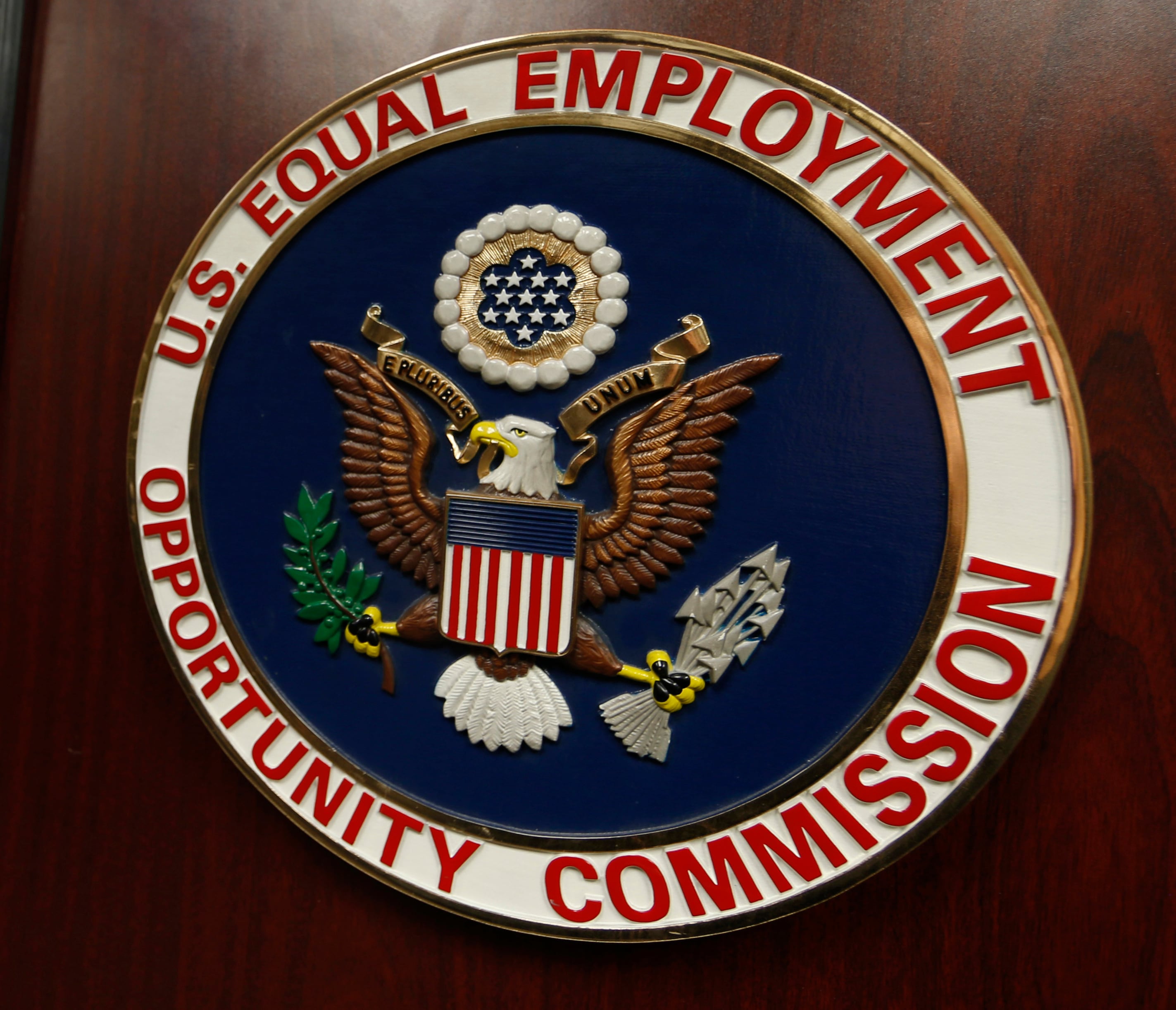 FILE - The emblem of the U.S. Equal Employment Opportunity Commission is shown on a podium in Vail, Colo., Tuesday, Feb. 16, 2016, in Denver.