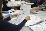 FILE - An election worker examines a ballot at the Clackamas County Elections office on May 19, 2022, in Oregon City, Ore, in Oregon's primary election.