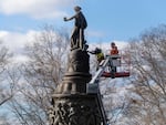 Workers prepare a Confederate memorial for removal in Arlington National Cemetery on Monday.