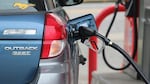 A gas pump nozzle rests in a vehicle, filling the tank with gas.