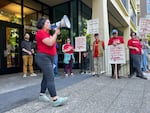 Portland State University American Association of University Professors president Emily Ford (left, with bullhorn) rallies union members on June 5, 2024. Ford expects a majority of non-tenure track faculty members will receive layoff notices.