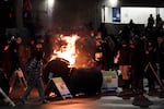 A trash can burns as people take part in a protest against police brutality, late Sunday, Jan. 24, 2021, in downtown Tacoma, Wash., south of Seattle.