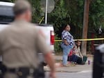 People sit on the curb outside of Robb Elementary School in Uvalde, Texas, on May 24, 2022.