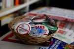 A bowl of buttons sit on top a pile of campaign signs against various fossil fuel projects in the Pacific Northwest.