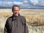 A man stands in a field during the daytime.