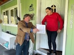 Morrow County Commissioner Jim Doherty is showing Silvia Hernandez her well water test results for nitrates which exceeded the federal safe drinking water limits by nearly five times on April 15, 2022.