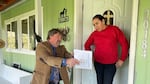 Morrow County Commissioner Jim Doherty is showing Silvia Hernandez her well water test results for nitrates which exceeded the federal safe drinking water limits by nearly five times on April 15, 2022.