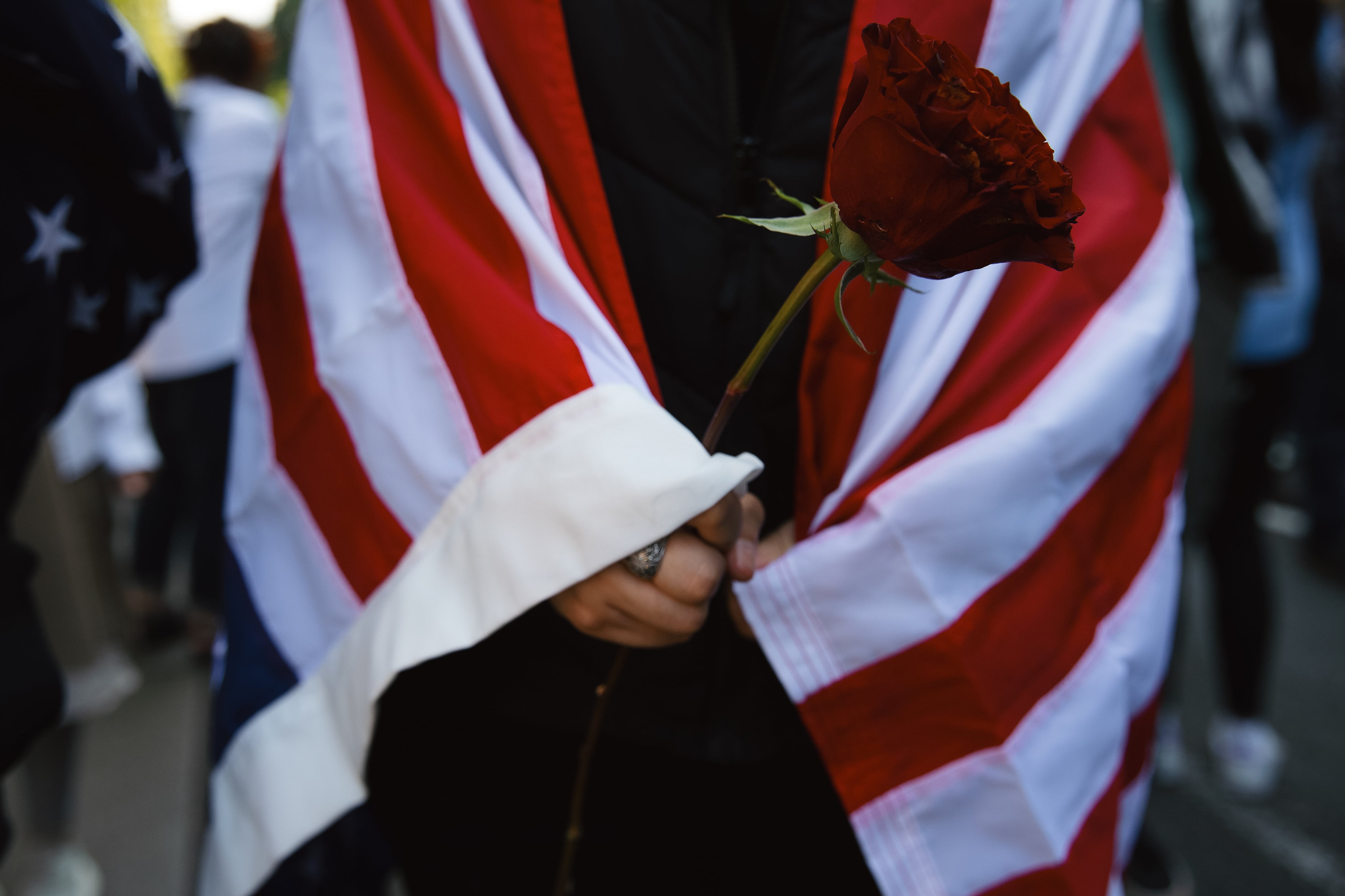 Seattle: Imelda, a demonstrator, holds a red rose while draped in an American flag while protesting.