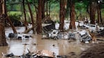 Wrecked vehicles and trailers along the Guadalupe River in Kerrville, Texas.