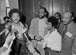 This March 26, 1972 file photo shows the Rev. Jesse Jackson speaking to reporters at the Operation PUSH Soul Picnic in New York as Tom Todd, vice president of PUSH, from second left, Aretha Franklin and Louis Stokes.