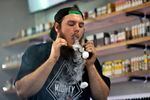 In this Tuesday, Sept. 3, 2019, photo, Devin Lambert, the manager at Good Guys Vape Shop, exhales vapor while using an e-cigarette in Biddeford, Maine.